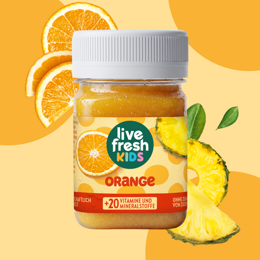 LiveFresh Kids Orange in a glass against an orange background with fresh orange slices and pineapple chunks. The label reads “live fresh KIDS,” “ORANGE,” and “+20 VITAMINS AND MINERALS.”