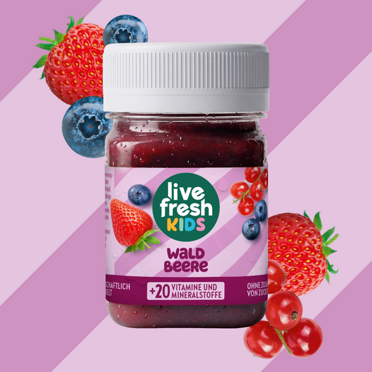LiveFresh Kids Wild Berries in a jar against a purple background with strawberries, blueberries, and red berries. The label reads “live fresh KIDS,” “WALD BEERE,” and “+20 VITAMINS AND MINERALS.”