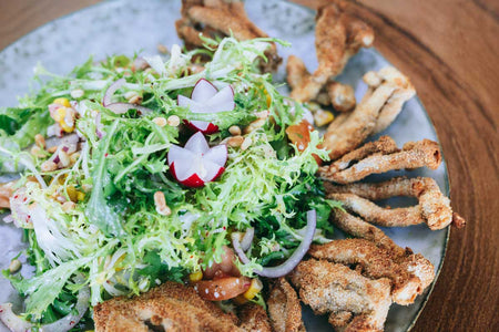 Knusprige Enoki-Pilze auf Frisée-Gemüsesalat