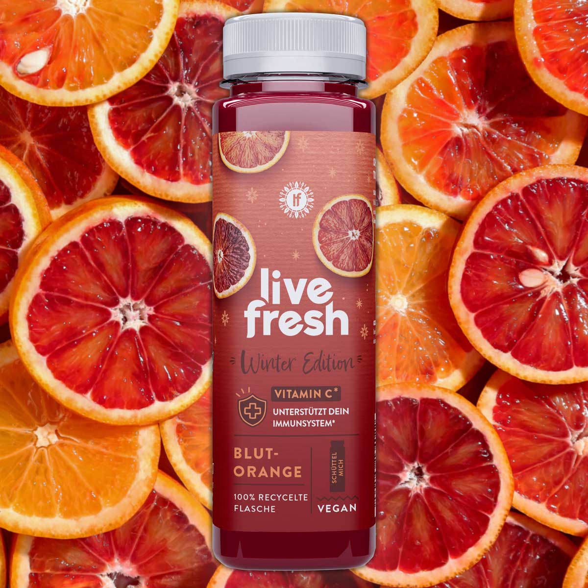 Blutorangensaft von LIveFresh in der Winter Edition mit Blutorangen im Hintergrund