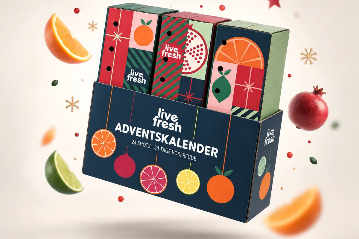 LiveFresh Shots-Adventskalender. Unter LiveFresh Kalender mit Früchten im Hintergrund und weihnachtlicher Deko 