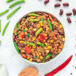 Tiefkühlgericht „Gemüse Chili“ von LiveFresh in einer Schale, mit Kidneybohnen, grünen Bohnen, Mais, Paprika und pflanzlichem Hack, umgeben von Zutaten wie Chili, Bohnen und Gewürzen auf einer hellen Unterlage.